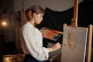 Kadın sanatçı renk paleti ve şövale Studio karşı ayakta fırça ile. Yaratıcı boya, ressam çizim portre, arka plan atölye iç