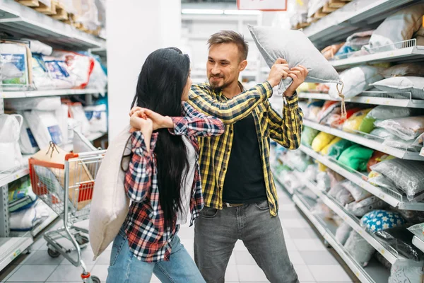 スーパー マーケット 枕投げの遊び心のあるカップル 家族のショッピングに男性と女性のお客様 男性と女性の家のための商品を購入 — ストック写真