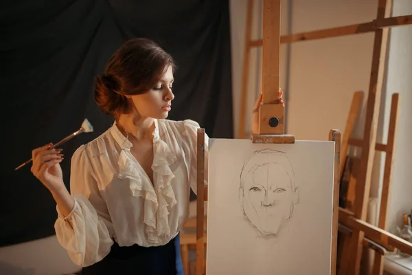 ブラシに敵対スタジオ イーゼルとかわいい女性画家 創造的な塗料 女性描画鉛筆スケッチ 背景にワーク ショップ インテリア — ストック写真
