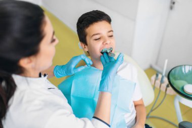 Kadın diş hekimi diş, oğlum etkiliyor diş sandalye, çocuk diş hekimliği, çocuk stomatology