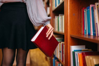Kadın kişi Üniversite Kütüphanesi içinde Bookshelf de kitapla. Bilgi deposu, eğitim kadın