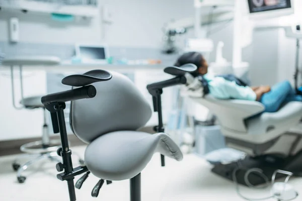 ビュー歯科クリニック バックで椅子に座っている女性患者 キャビネットの歯科 歯のケアで女性 — ストック写真