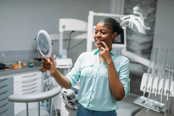 微笑的女性患者在镜子 牙科诊所 医疗设备的背景下看牙齿 妇女在牙科柜 口腔医学 牙齿护理 — 图库照片