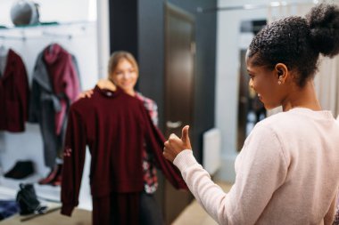 Alışveriş iki kadın giysiler, seçmek. Shopaholics giyim mağazası, tüketim yaşam tarzı, moda