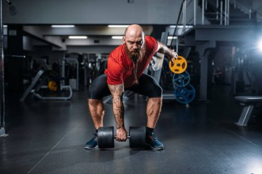 Spor salonunda dumbbells ile egzersiz yaparak atletik erkek hırsızı. Sakallı sporcu spor kulübü, sağlıklı yaşam tarzı