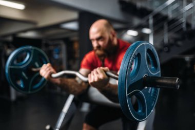 Kaslı sporcu ile Halter salonunda egzersiz yapmak. Sakallı adam Spor Kulübü, sağlıklı bir yaşam tarzı olarak çalışma