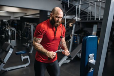 Spor salonunda egzersiz makinede eğitim spor giyim, güçlü atlet. Sakallı adam Spor Kulübü, sağlıklı bir yaşam tarzı olarak çalışma