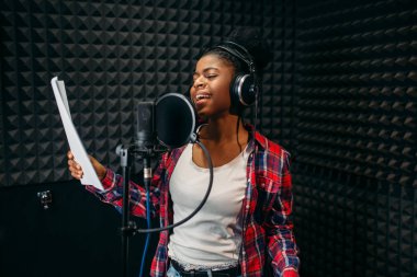 Kulaklık şarkı ses kayıt stüdyosu olarak genç kadın. Müzisyen dinler kompozisyon, profesyonel müzik karıştırma