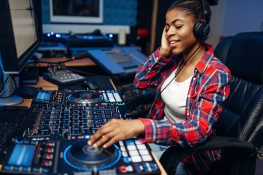Female sound operator working at the remote control panel in audio recording studio.  Musician at the mixer, professional music mixing clipart