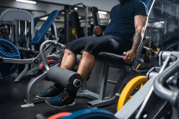 肌肉发达的男性在健身器材上训练腿 在健身房训练 在运动俱乐部锻炼的胡子男子 健康的生活方式 — 图库照片