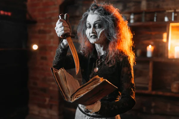 可怕的女巫拿着魔法书和刀 黑暗的巫术力量 精神的降神 女预言者叫精神 可怕的未来柜员 — 图库照片