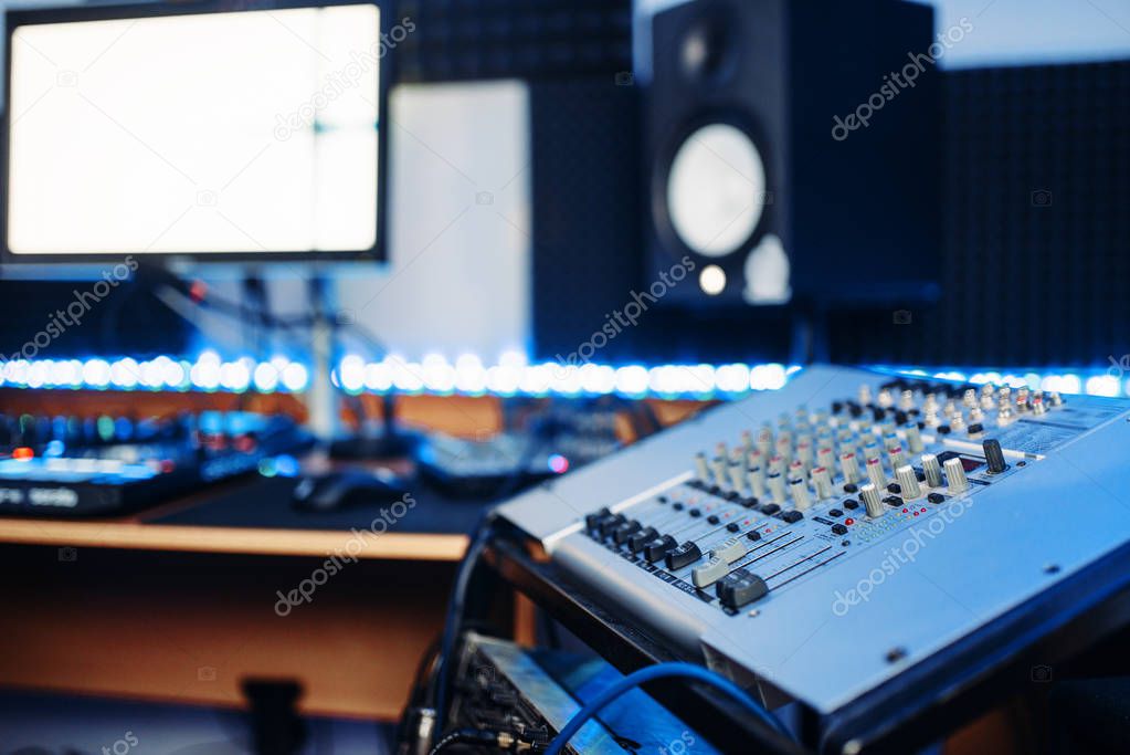 Sound operator and female performer in headphones listens composition in recording studio. Professional audio and music mixing technology