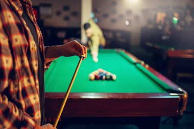 İki erkek Bilardo oyuncular işaret ile rekabet masada renkli topları ile başlar. Erkek spor bar Amerikan pool oyunu oynar