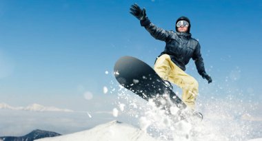 Male snowboarder, dangerous downhill in action, front view. Snowboarding is an extreme winter sport. Man on snowboard in jump clipart