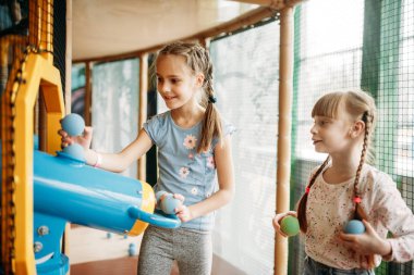 İki küçük kız çocuk oyun Merkezi hava tabancası çalış. Heyecanlı Childs'ın kapalı oyun alanında eğleniyor. Eğlence merkezinde oynayan çocuklar
