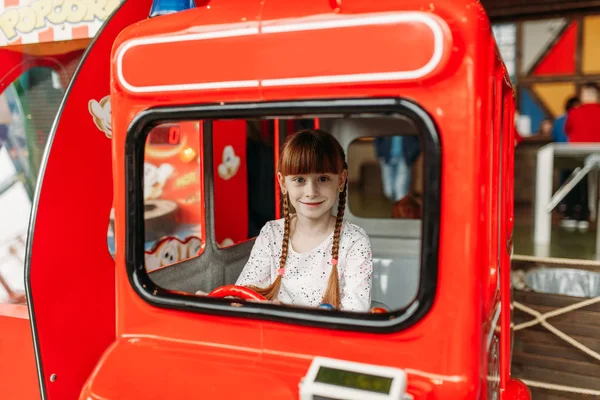 小女孩扮演公交司机 游戏机 儿童娱乐中心 兴奋的孩子在室内游乐场玩耍 在游乐中心玩耍的女童 — 图库照片