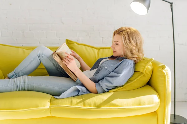 Mujer Joven Acostada Acogedor Sofá Amarillo Leyendo Libro Sala Estar —  Fotos de Stock