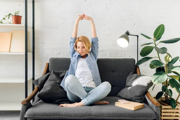 Jonge Vrouw Met Boek Strekken Zich Uit Gezellige Zwarte Bank — Stockfoto