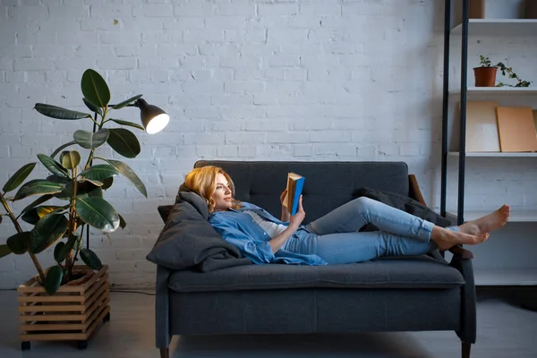 Mujer Joven Acostada Acogedor Sofá Negro Leyendo Libro Sala Estar —  Fotos de Stock