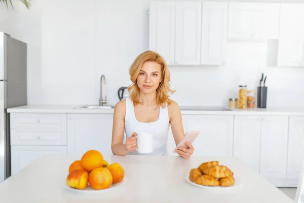 果物とベーキングのテーブルで幸せな女性 キッチンで朝食 朝の家庭での女性人 健康的な栄養とライフスタイル — ストック写真
