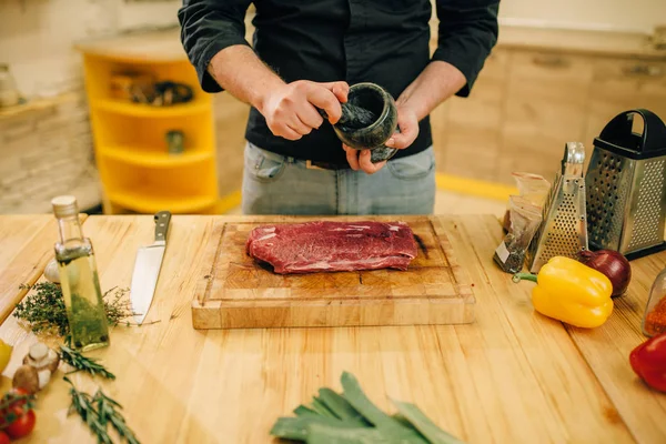 Мужчина Посыпает Сырое Мясо Приправами Кухонный Интерьер Заднем Плане Шеф — стоковое фото