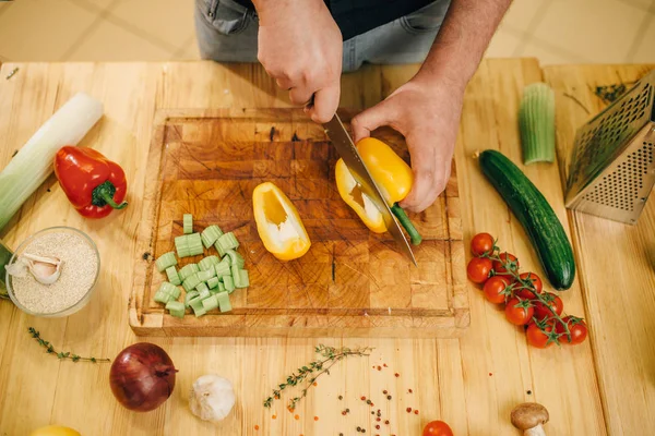 Cuoco Maschio Con Coltello Taglia Pepe Giallo Tavola Legno Vista — Foto Stock