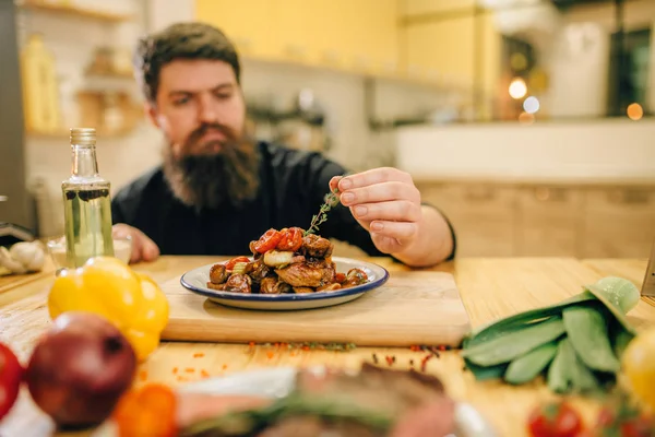 Erkek Şef Otlar Gurmeler Için Bir Yemeği Arka Planda Mutfak — Stok fotoğraf
