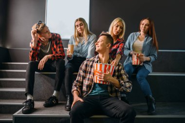 Gösteri den önce sinema salonunda eğlenen bir grup arkadaş. Sinemada bekleyen erkek ve kadın gençler