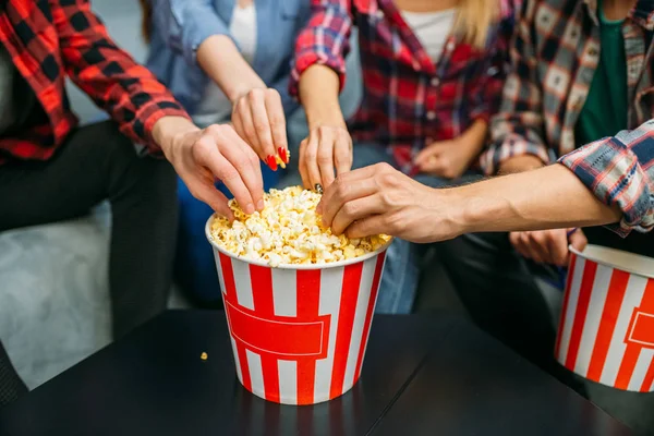 上映前にポップコーンを食べたり シネマホールで楽しみながら楽しむ人々のグループ 映画館でソファに座っている男女の若者 — ストック写真