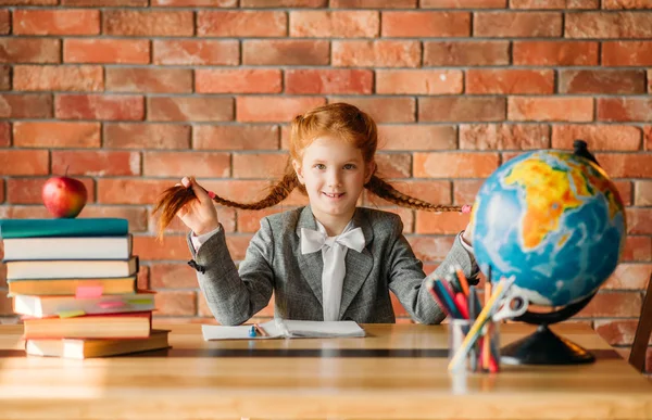 テーブルに座っている愛らしい女子高生 正面の景色 教科書 リンゴと地球儀を持つ机の上の女子生徒 宿題をしている若い女の子 — ストック写真