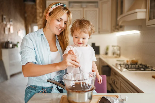Jovem Mãe Com Sua Filha Misturando Chocolate Derretido Uma Tigela — Fotografia de Stock
