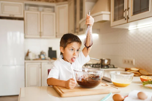 ボウルに溶けたチョコレートを混ぜる若い子供 台所で調理かわいい男の子 幸せな子供は甘いデザートを準備します — ストック写真