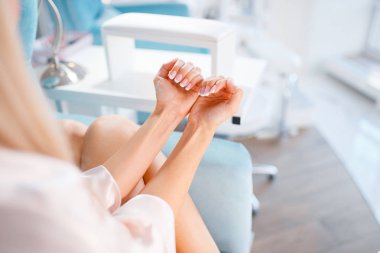 Kadın müşteri güzellik mağazasında çivi gösterir. Profesyonel manikür ve pedikür servisi, el ve bacak tedavisi, güzellik salonunda müşteri, manikürcü kadın