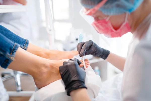 美容美发 清洁程序 美容店的女客户指甲护理治疗 戴手套的医生与客户的脚趾甲合作 — 图库照片