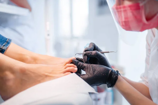 美容师沙龙 抛光程序 美容店的女客户指甲护理治疗 戴手套的医生与客户的脚趾甲合作 — 图库照片