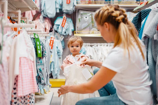 子供の店で服を選ぶ彼女の小さな女の子と母 一緒にスーパーマーケットでドレスを買うママと子供 家族の買い物 — ストック写真