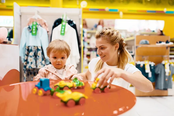 가게에서 놀고있는 그녀의 소녀와 어머니 엄마와 아이가 슈퍼마켓에서 장난감을 — 스톡 사진