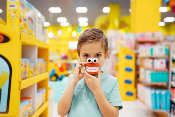 소년은 스토어 정면전망의 선반에 장난감을 있습니다 아들은 슈퍼마켓 고객에서 장난감을 — 스톡 사진