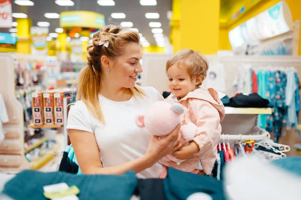 子供の店でぬいぐるみ犬を選択する彼女の小さな娘と母 一緒にスーパーマーケットでおもちゃを買うママと子供 家族の買い物 — ストック写真