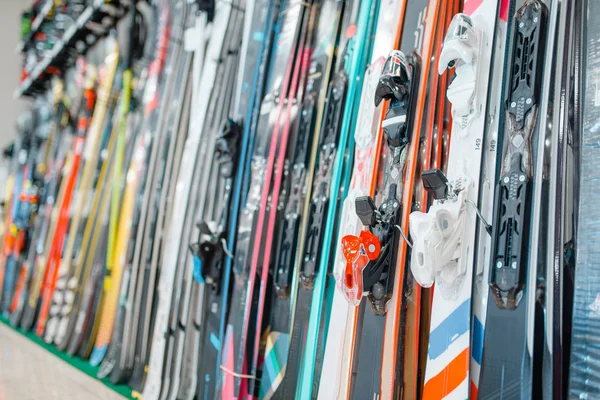 Rows of skis in sports shop, closeup, nobody. Winter extreme, active leisure, showcase with equipment