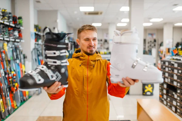 Чоловік Показує Білі Чорні Лижі Або Сноубордистські Черевики Спортивному Магазині — стокове фото