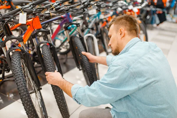 男は自転車のタイヤをチェックし スポーツショップで買い物をします 夏の季節の極端なライフスタイル アクティブレジャーストア 顧客購入サイクル機器 — ストック写真