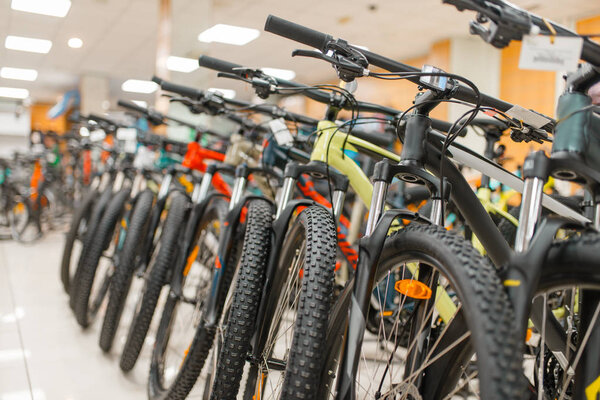 Гребцы горных велосипедов в спортивном магазине, никто. Летний активный отдых, витрина с велосипедами, продажа велосипедов
