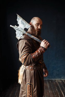 Angry viking with axe dressed in traditional nordic clothes, barbarian image. Ancient male warrior. clipart