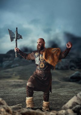 Viking balta ile geleneksel İskandinav giysileri kayalık dağlarda ayakta giymiş ve ellerini kaldırdı, barbar. İskandinav antik savaşçı