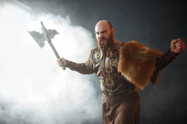 Baltalı kızgın viking, savaş ruhu, barbar imajı. Karanlık arka planda duman antik savaşçı