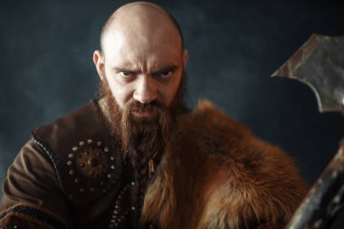 Baltalı viking portresi, savaş ruhu, barbar imgesi. Karanlık arka planda duman antik savaşçı