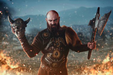 Geleneksel İskandinav giysileri giymiş kızgın viking balta ve insan kafatası tutar, ateşte savaş. İskandinav antik savaşçı