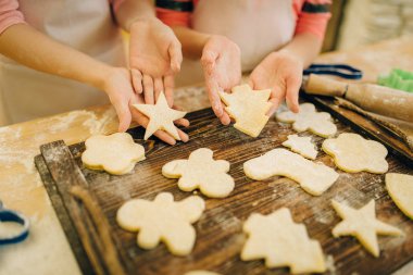 İki küçük kız şefleri ahşap bir tahta üzerinde kurabiye yaymak, mutfakta fırın hazırlama, komik Fırıncılar. Çocuklar pasta pişirme ve eğlenmek, çocuk aşçılar hazırlamak pasta