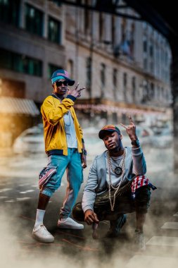 Kapaklı iki Afrikalı rapçi, arka planda şehir caddesi. Cityscape karşı Rap sanatçıları, yeraltı müzik konseri, kentsel tarzı